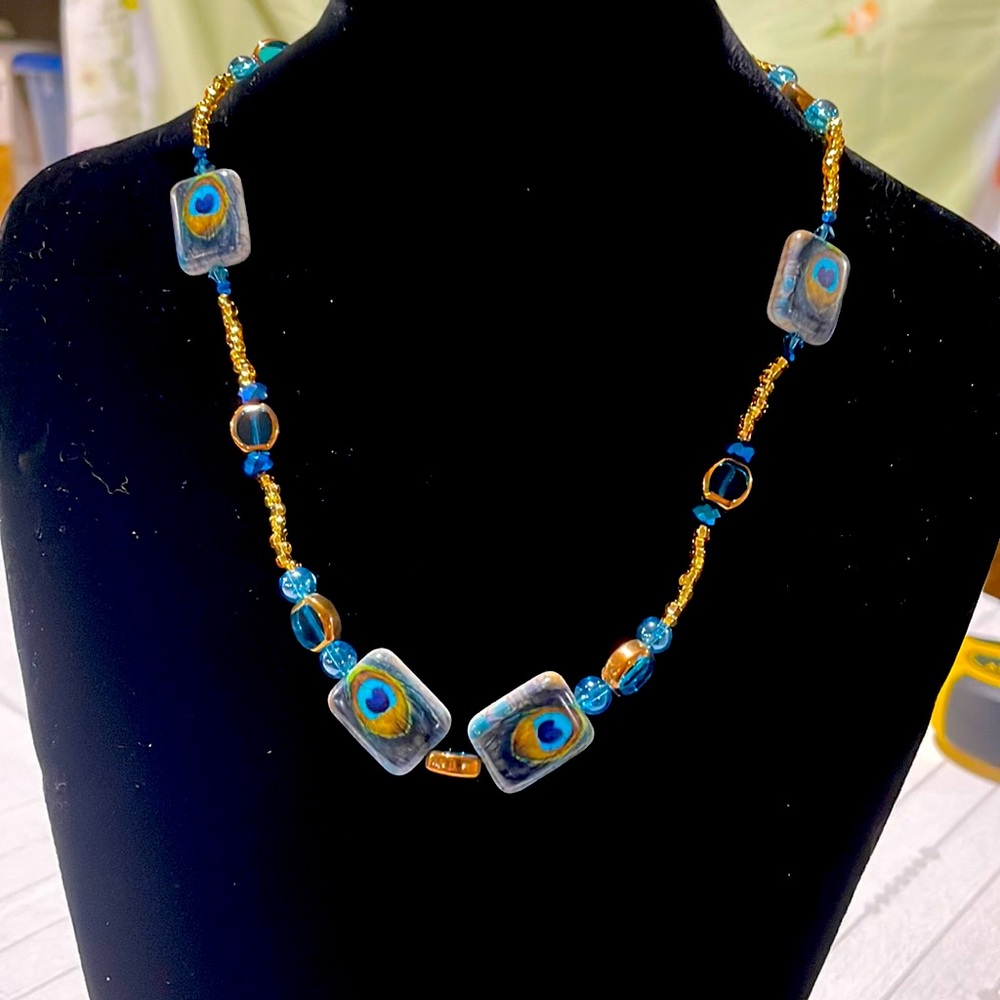 Handmade necklace with peacock feather design.